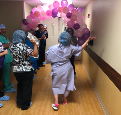 woman in hospital with pink balloons overhead