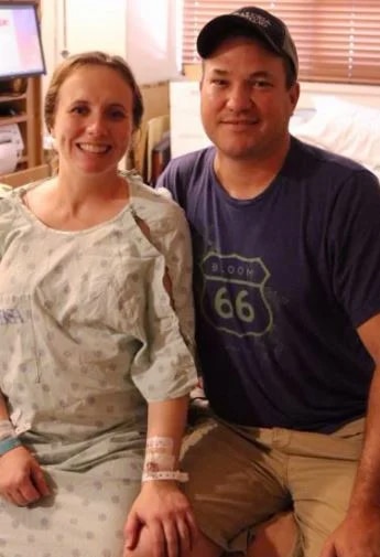 woman in hospital gown sitting by husband