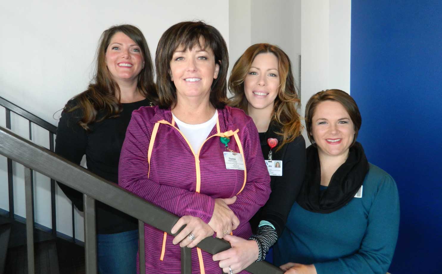 4 women posing in stairwell